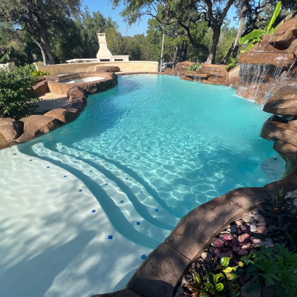 Professional technician from Ph.D. Pool Care performing pool repair in Bastrop, Texas, focusing on a cracked pool tile.